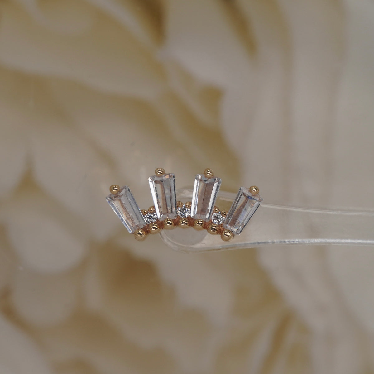 Front view of Buddha Jewelry’s “Crown Jewels” in 14k yellow gold, featuring shimmering crystals arranged in an ornate crown-like shape.
