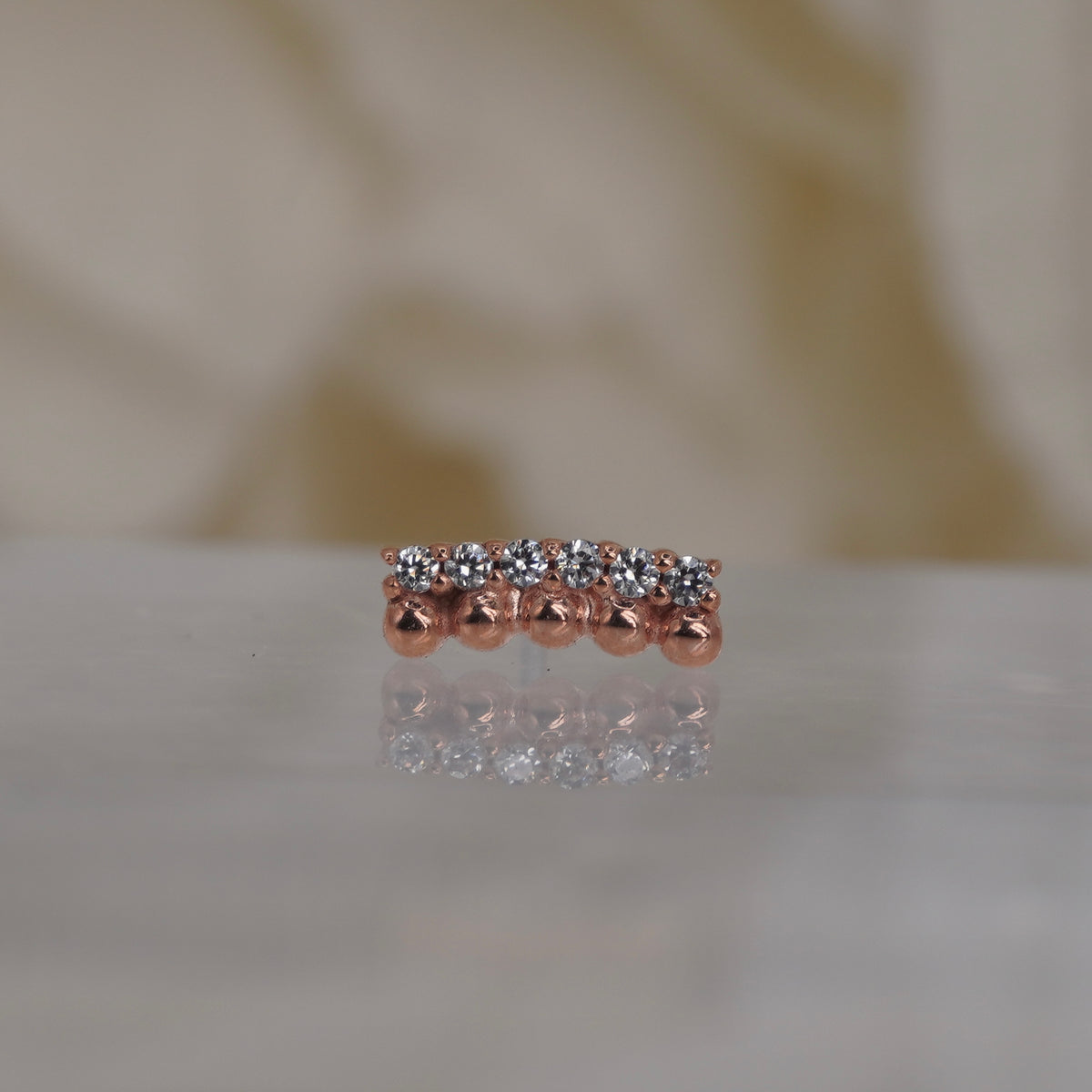 Front view of Buddha Jewelry’s “Prophesy” in 14k rose gold, featuring polished gold beads alongside a sleek row of crystals.