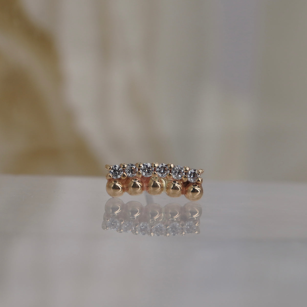Front view of Buddha Jewelry’s “Prophesy” in 14k yellow gold, featuring polished gold beads alongside a sleek row of crystals.