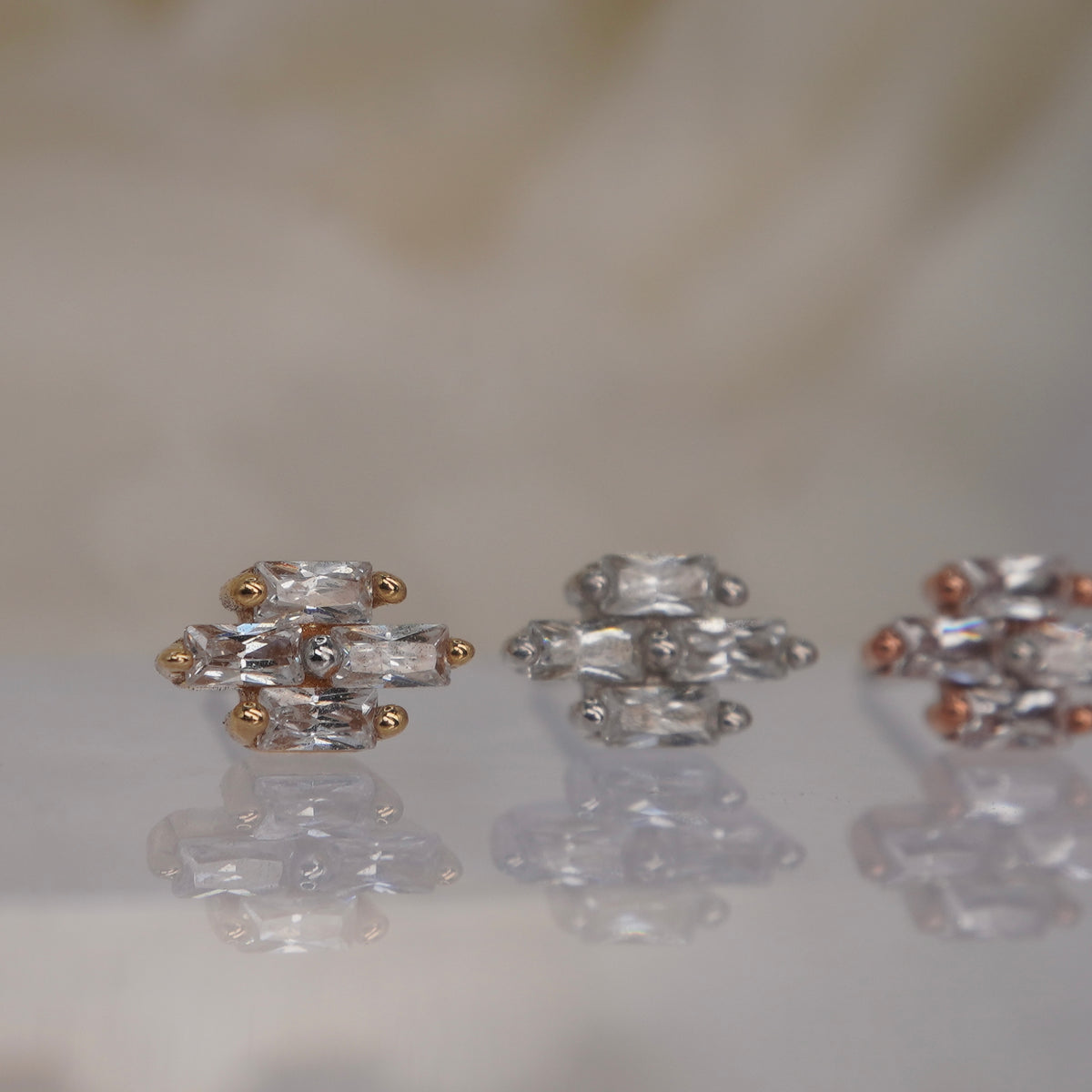 Angled view of Buddha Jewelry’s “Fate” in 14k yellow, white, and rose gold, showing the dimensional crystal arrangement and crisp, elongated stone shapes.
