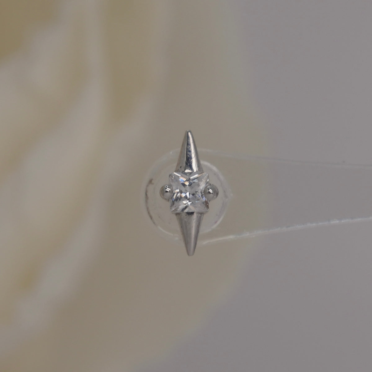 Front view of Buddha Jewelry’s “Elemental” in 14k white gold, featuring a central square-cut crystal between pointed gold tips.