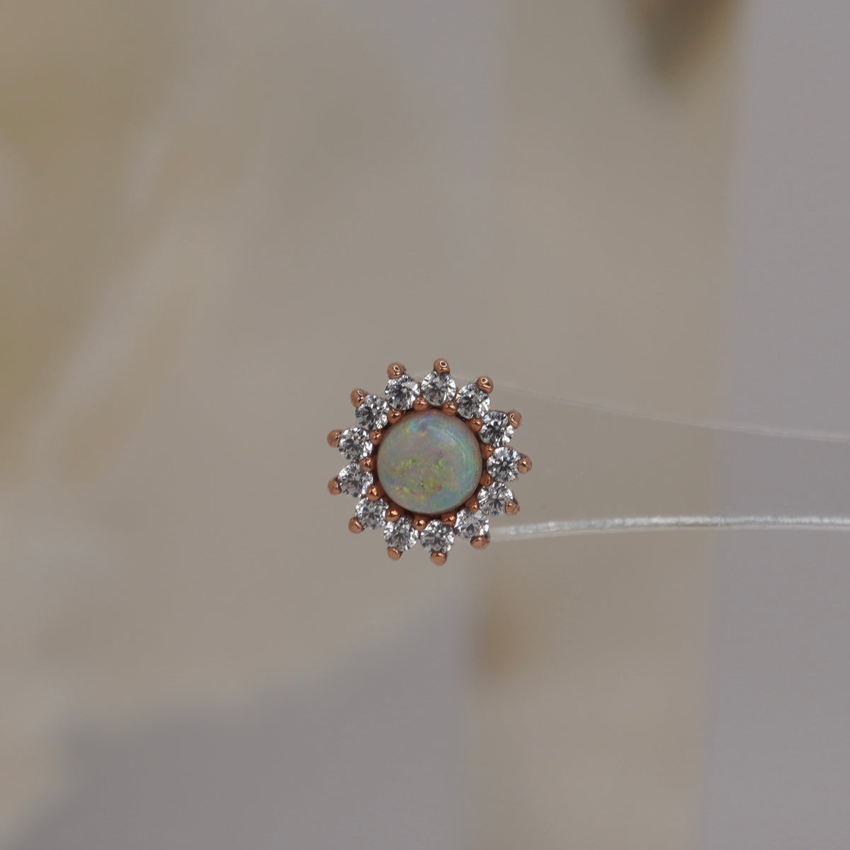 ront view of Buddha Jewelry’s “Delphine” in 14k rose gold, featuring a glowing opal framed by sparkling crystal petals.