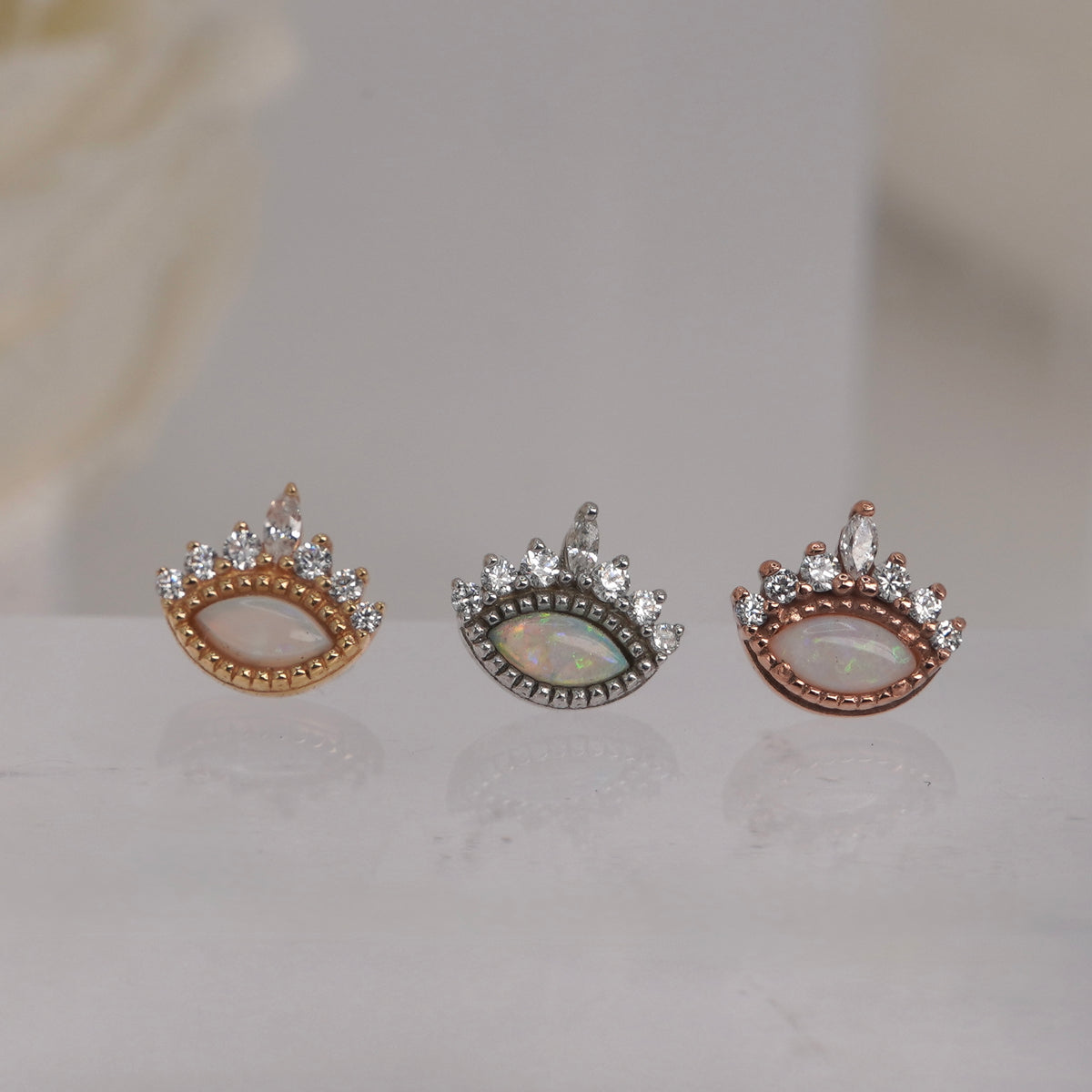 Front view of Buddha Jewelry’s “Enchant” in 14k yellow, white, and rose gold, featuring a luminous opal center beneath a crown of sparkling crystals.
