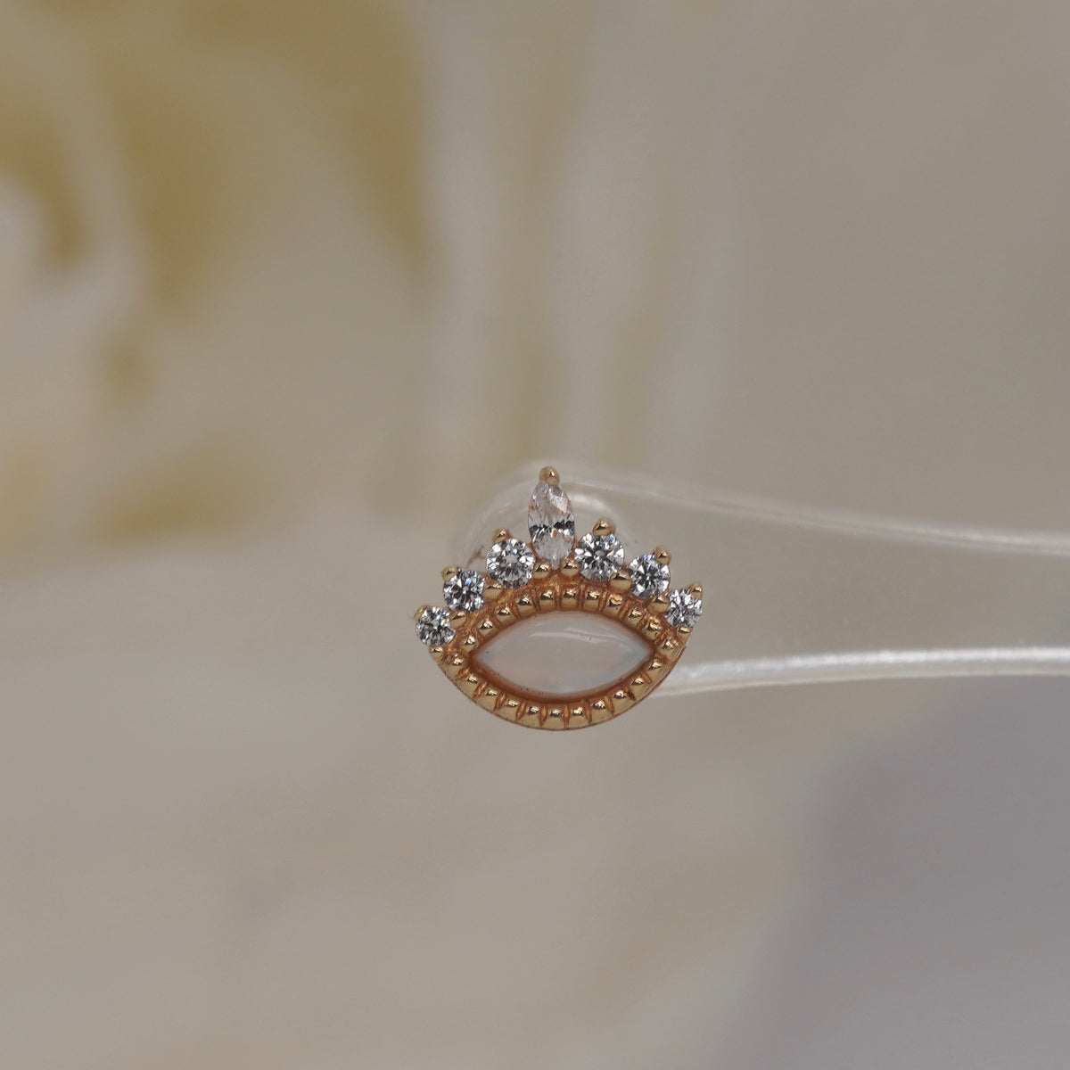 Front view of Buddha Jewelry’s “Enchant” in 14k yellow gold, featuring a glowing opal accented by a crown of crystals.