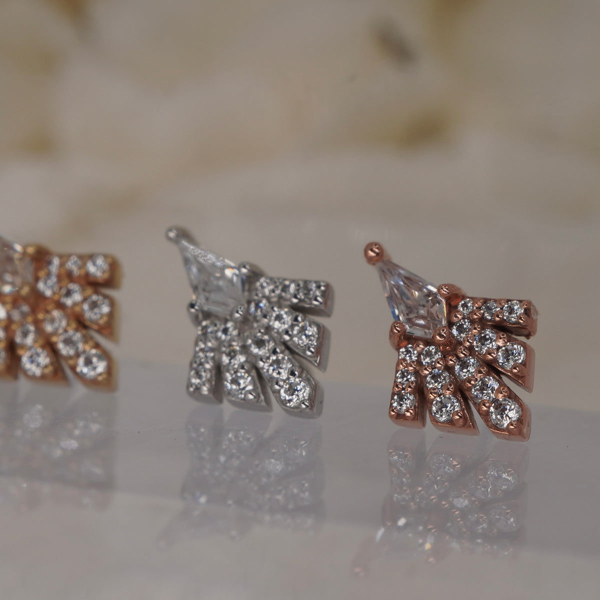 Angled view of Buddha Jewelry’s “Savor” in 14k yellow, white, and rose gold, showing the dimensional stone arrangement and art deco-inspired silhouette.