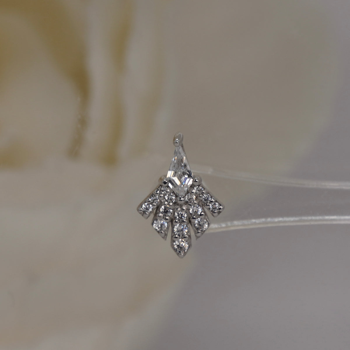 Front view of Buddha Jewelry’s “Savor” in 14k white gold, featuring a kite-shaped crystal and a spreading fan of sparkling stones.