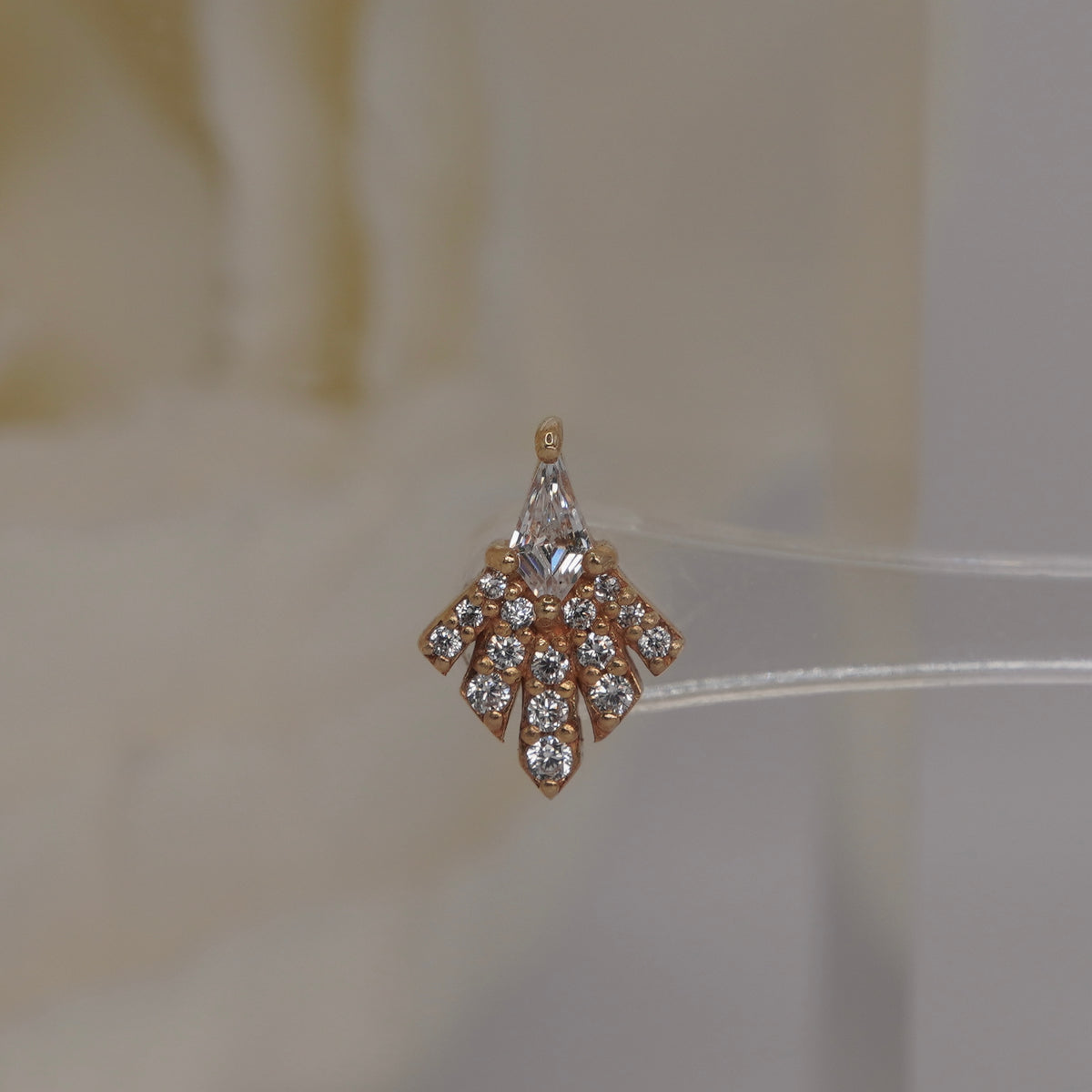 Front view of Buddha Jewelry’s “Savor” in 14k yellow gold, featuring a kite-shaped crystal and a spreading fan of sparkling stones.