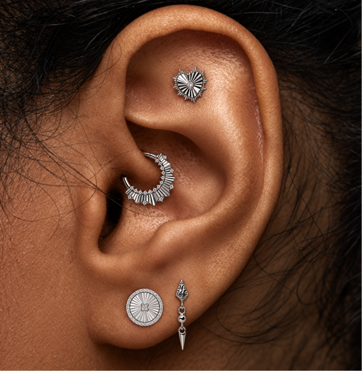 Buddha Jewelry’s white gold jewelry worn in piercings, showing its textured fan design and genuine diamond accents.