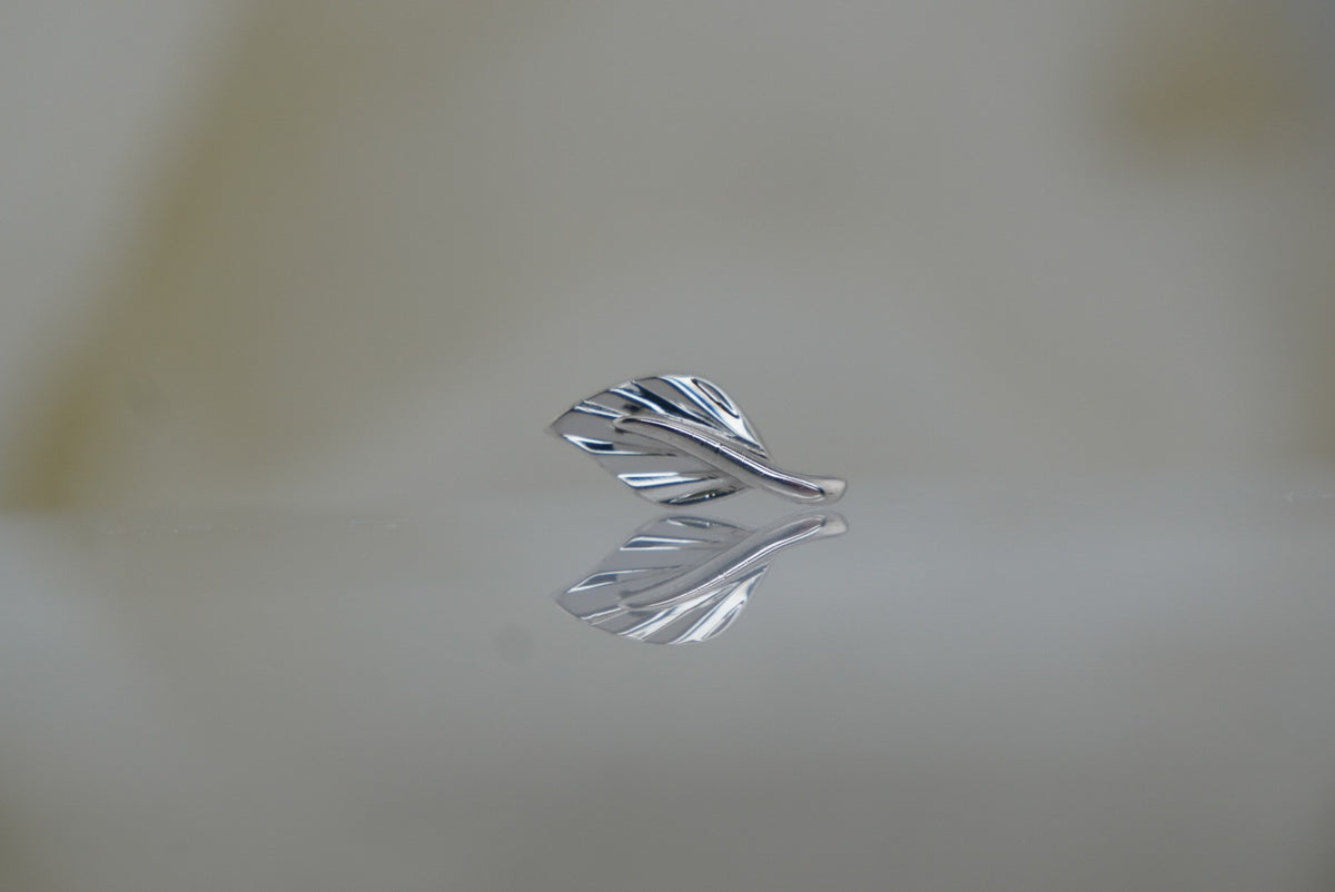 Front view of Buddha Jewelry’s “Essence” in 14k white gold, featuring a delicate leaf design with flowing, polished lines.
