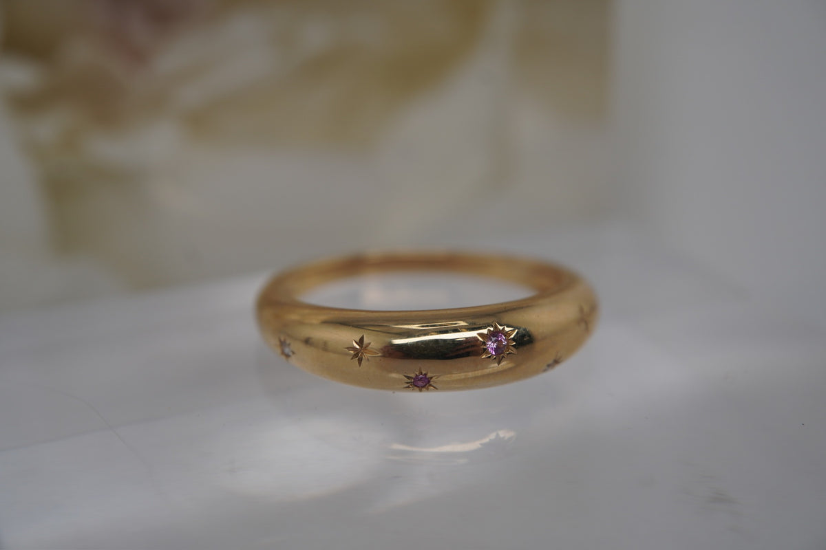 Angled view showing the Pink Sapphire and gold setting.