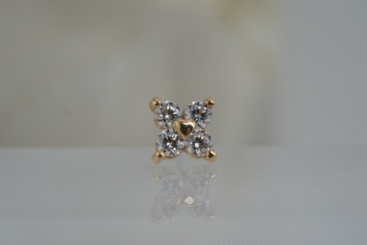 Front view of Buddha Jewelry’s “Corazon” in 14k yellow gold, featuring four shimmering crystals arranged around a polished gold heart.