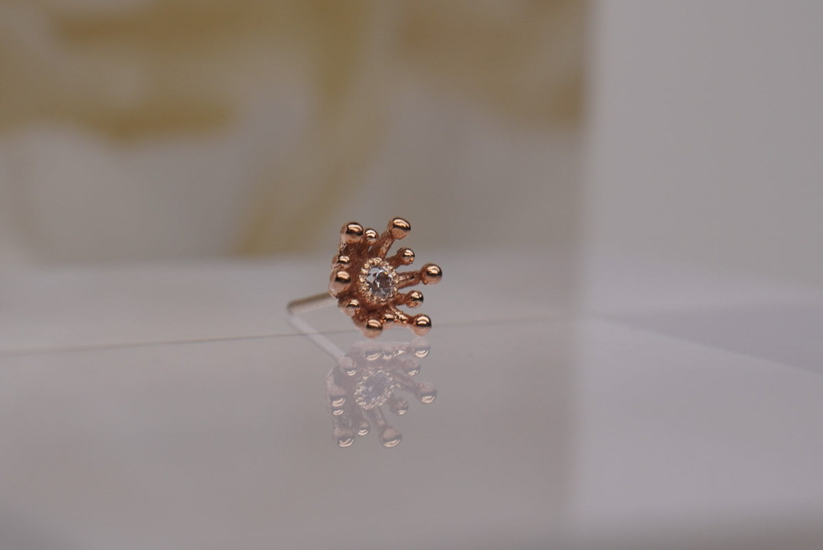 14k gold “Fire Star” threadless end in rose gold, angled view