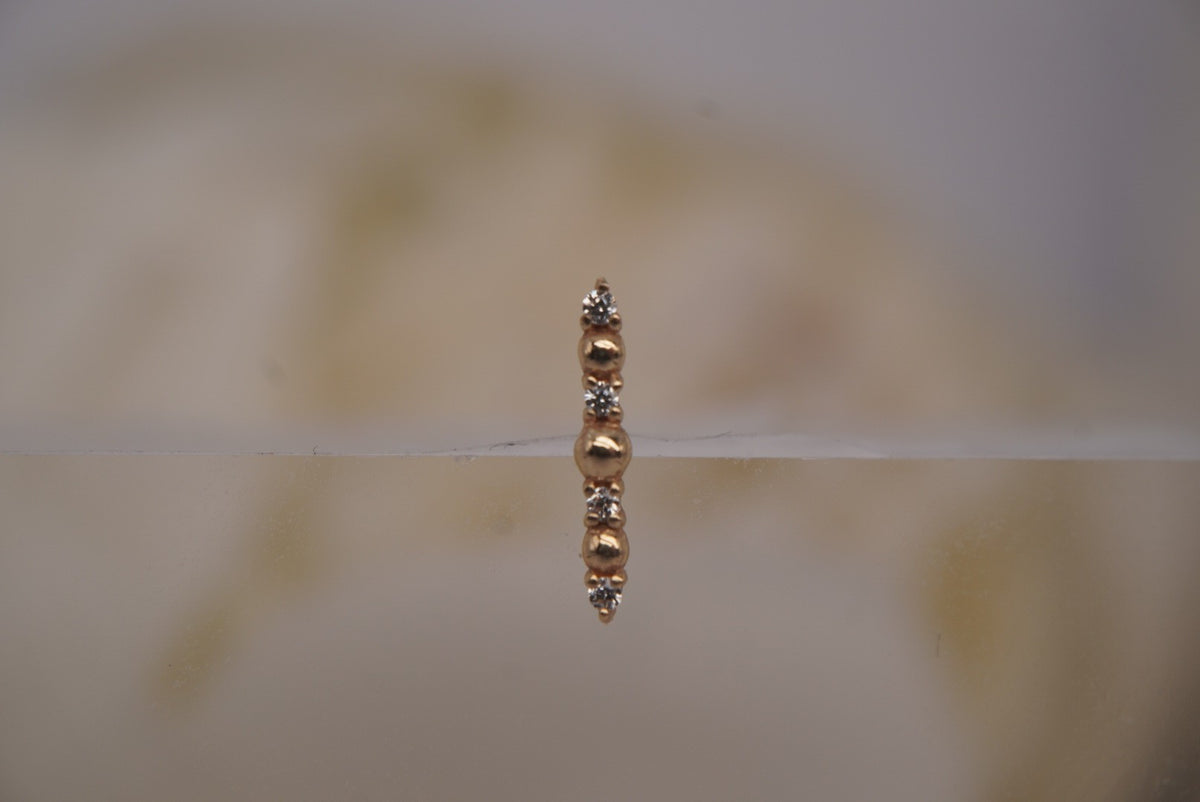 Front view of Buddha Jewelry’s “Chance” in 14k yellow gold, featuring alternating polished beads and shimmering crystals in a slim vertical arrangement.