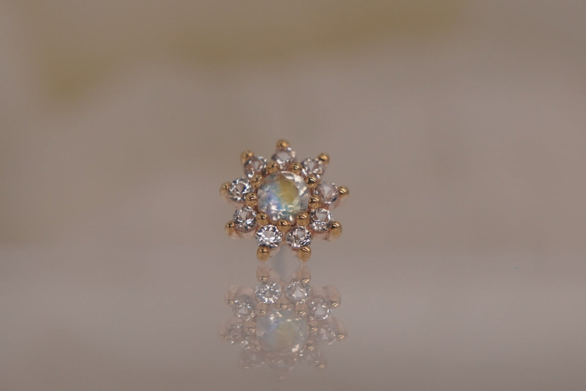 Front view of Buddha Jewelry’s “Eloise” in 14k yellow gold, featuring a glowing rainbow moonstone center framed by delicate white sapphire petals.
