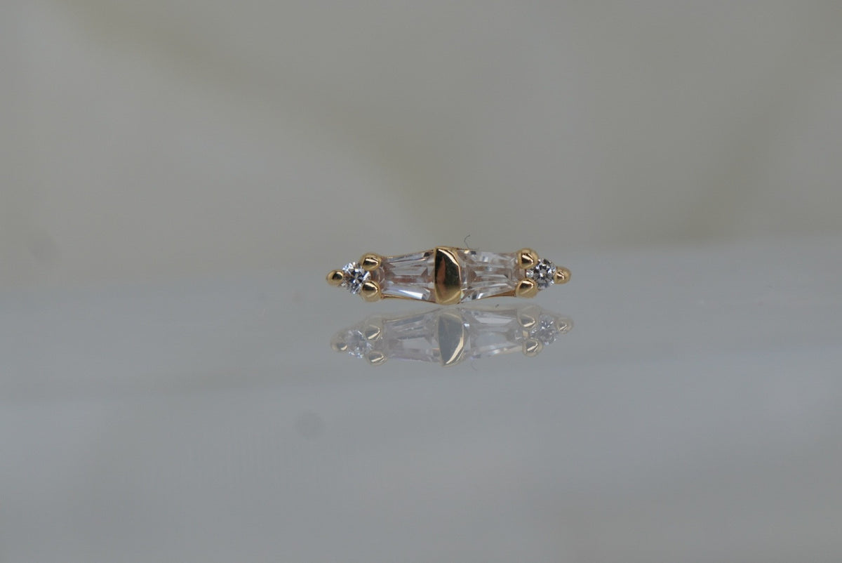 Front view of Buddha Jewelry’s “Essential” in 14k yellow gold, featuring alternating crystals in a clean, elongated linear design.