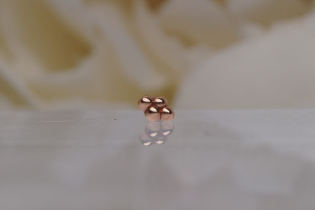 Front view of Buddha Jewelry’s “4 Bead Cluster” in 14k rose gold, featuring four polished beads arranged in a clean diamond silhouette.