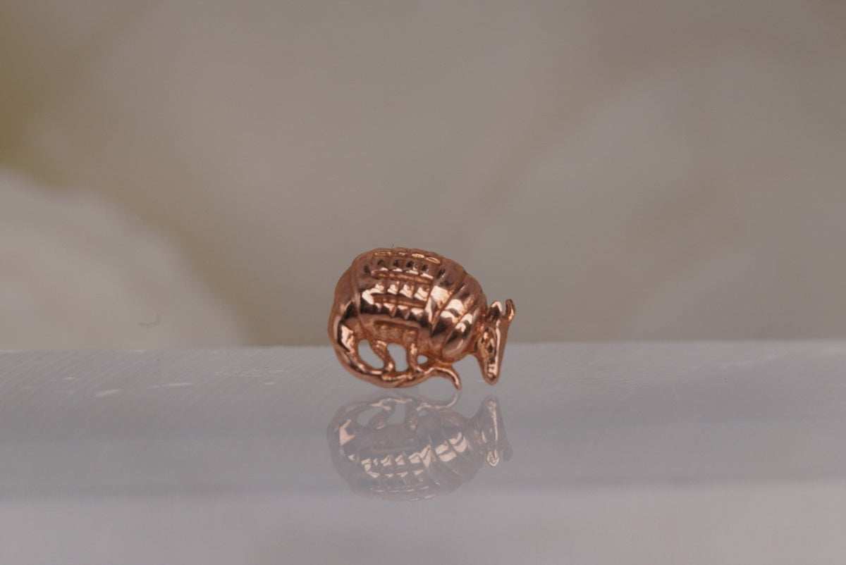 Front view of Buddha Jewelry’s “Let’s Roll” in 14k rose gold, featuring a curved armadillo design with a textured shell.
