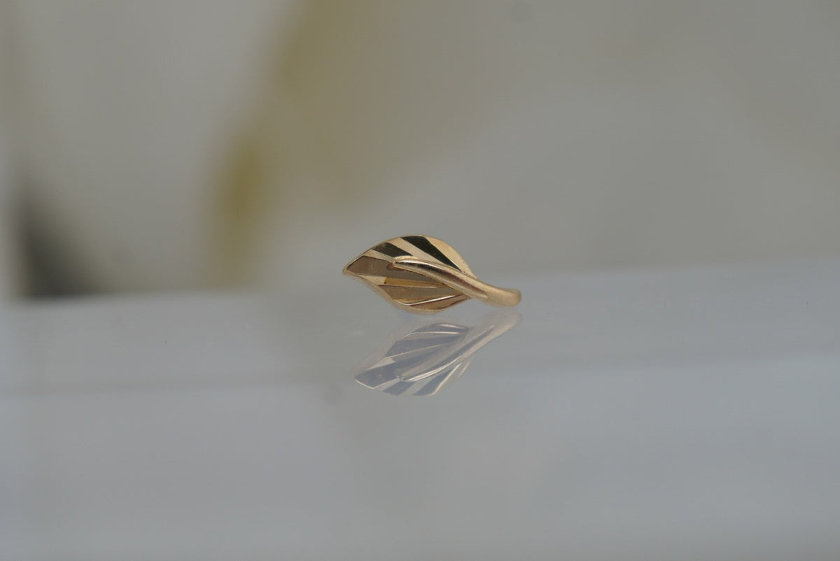 Front view of Buddha Jewelry’s “Essence” in 14k yellow gold, featuring a delicate leaf design with flowing, polished lines.
