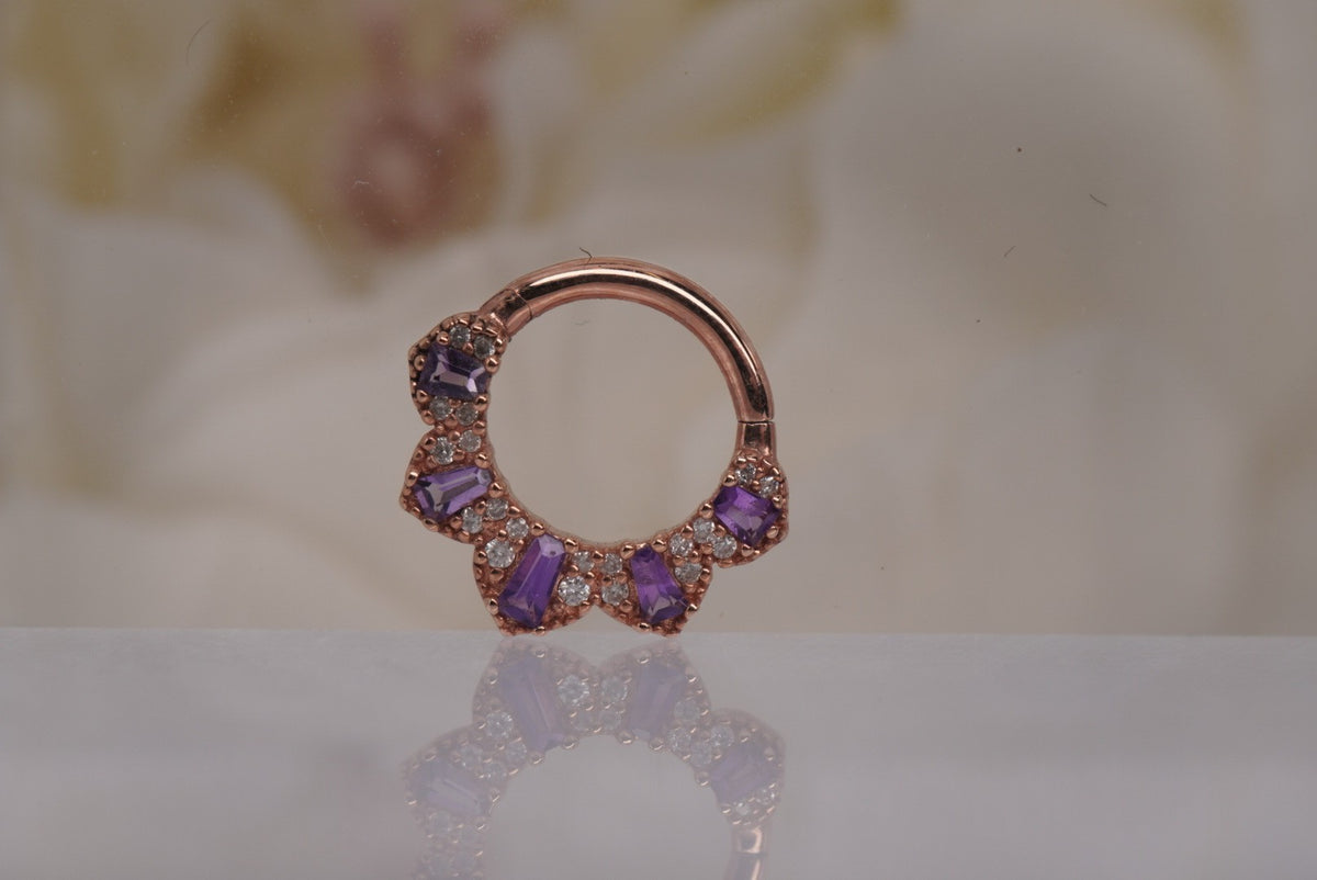 Front view of Buddha Jewelry’s “Gilty Pleasure” clicker in 14k rose gold, featuring a curved fan of amethyst baguettes accented with genuine white diamonds.