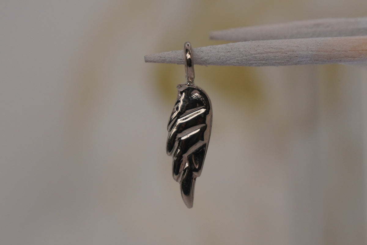 Side Facing Norvoch 14k Angel Wing Charm pendant in Yellow gold piercing charm, front view