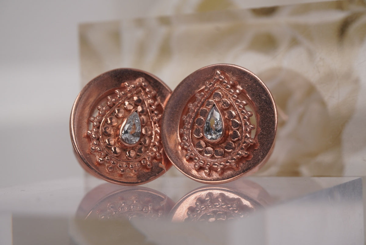 Angled front view of Buddha Jewelry’s “Deity Plug” in rose gold, highlighting the luminous crystal and dimensional beadwork.