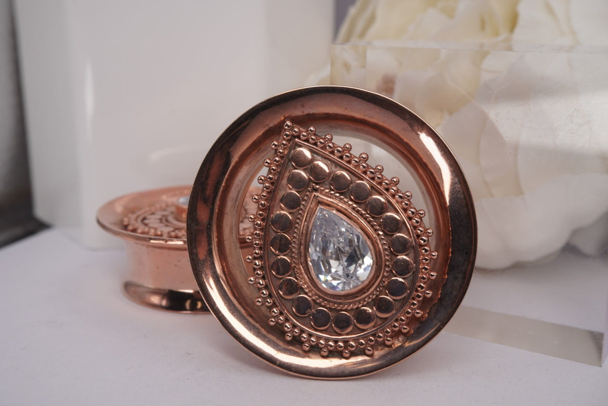 Front view of Buddha Jewelry’s “Deity Plug” in rose gold, featuring a bold Swarovski crystal center framed by intricate handmade beadwork.