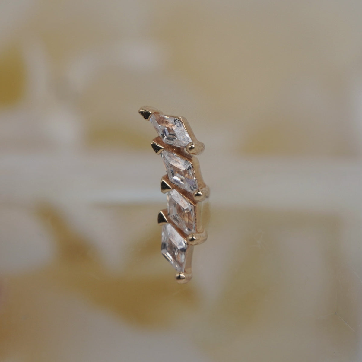 Side view of the Large Multiplicity threadless end, showing its gold profile and layered setting.