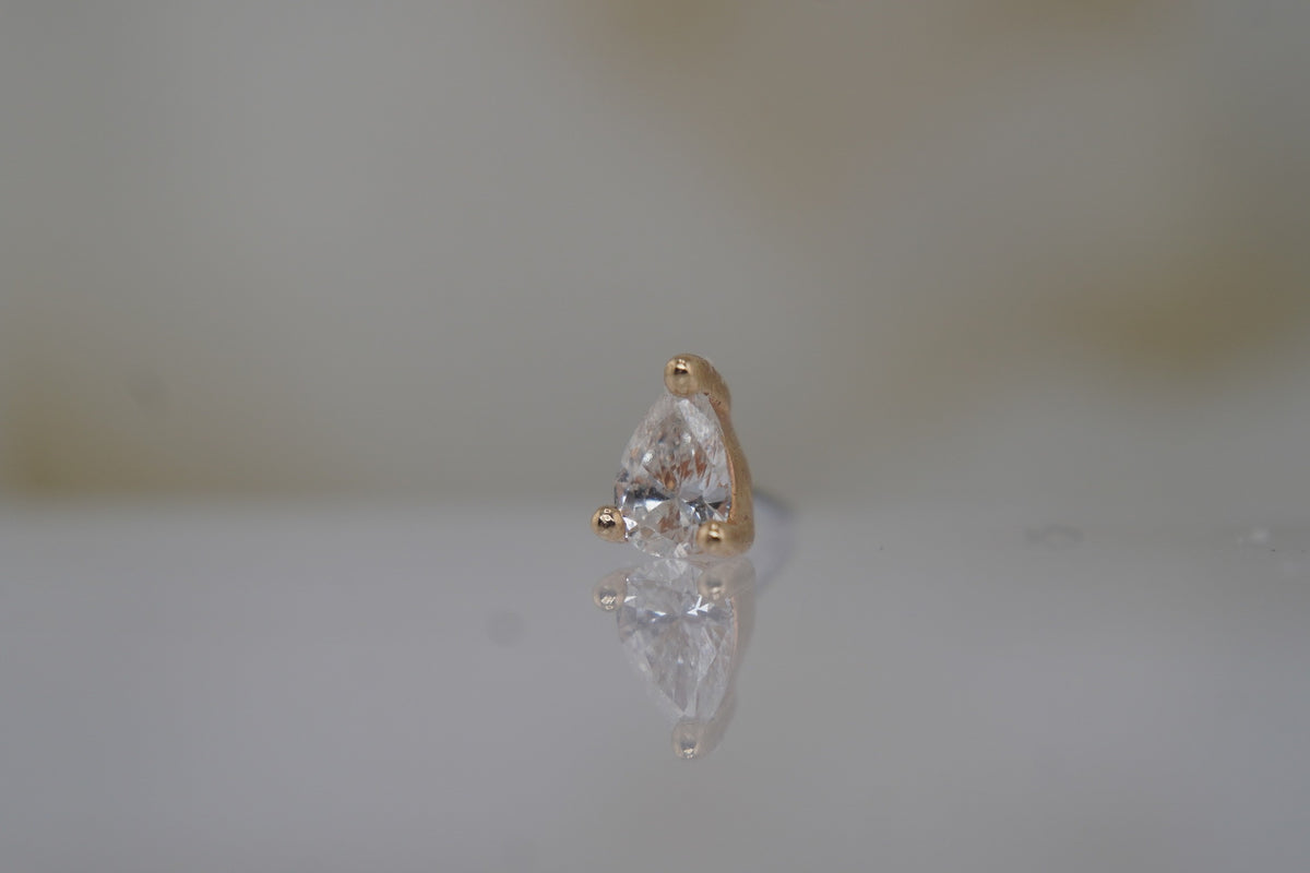 Angled view showing the diamond and its delicate gold prongs.