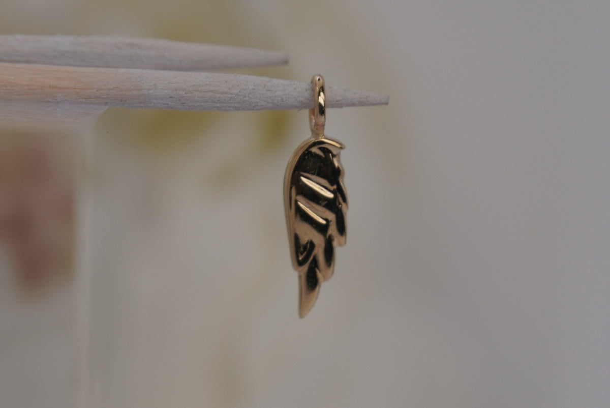 Side Facing Norvoch 14k Angel Wing Charm pendant in Yellow gold piercing charm, side view