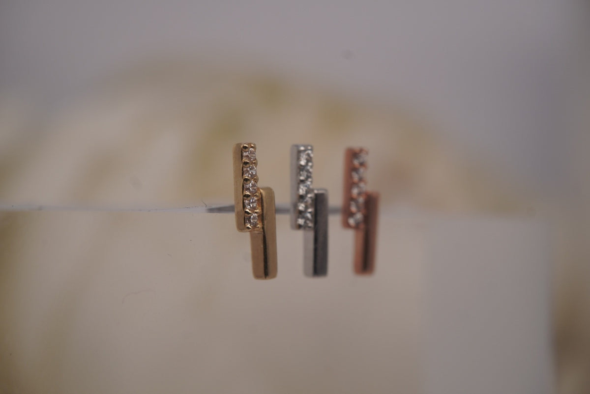 Angled view of Buddha Jewelry’s “Encore” in 14k yellow, white, and rose gold, highlighting the polished bars and sparkling crystal rows.