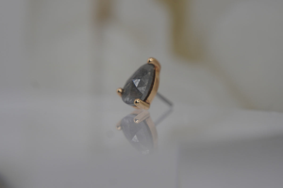 Side view of the pear-shaped diamond design, showing its gold profile.