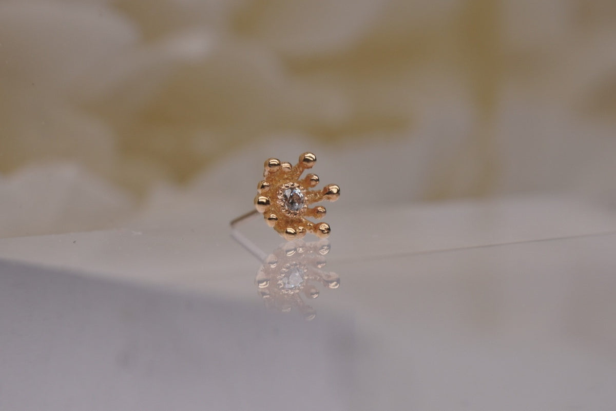 14k gold “Fire Star” threadless end in yellow gold, angled view