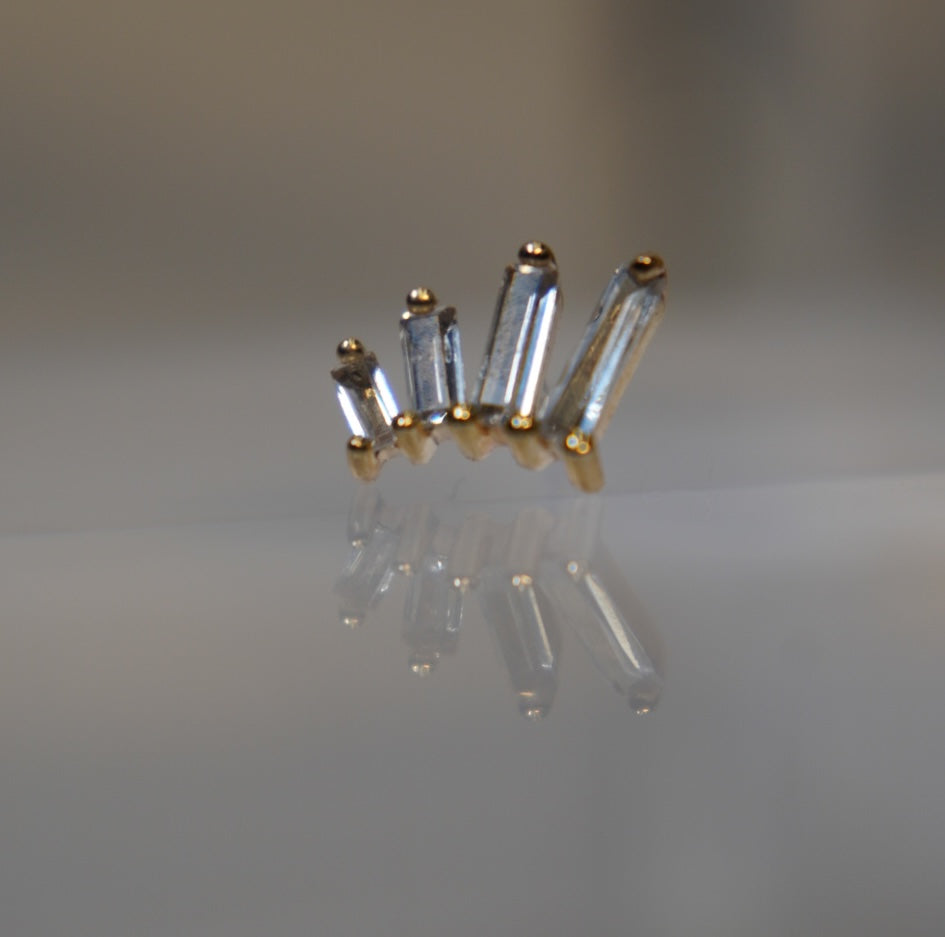 Angled view showing the three baguette stones and gold setting