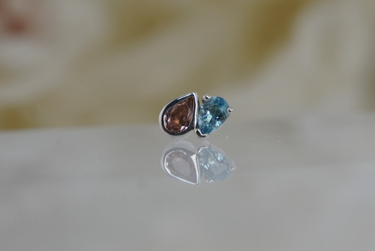Front view of Buddha Jewelry’s “Era” in 14k white gold, featuring pear-cut pink tourmaline paired with London Blue Topaz.