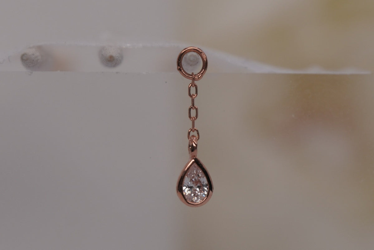 Front view of Buddha Jewelry’s “Concorde Chain” in 14k rose gold, featuring a fine chain leading to a faceted white topaz drop.