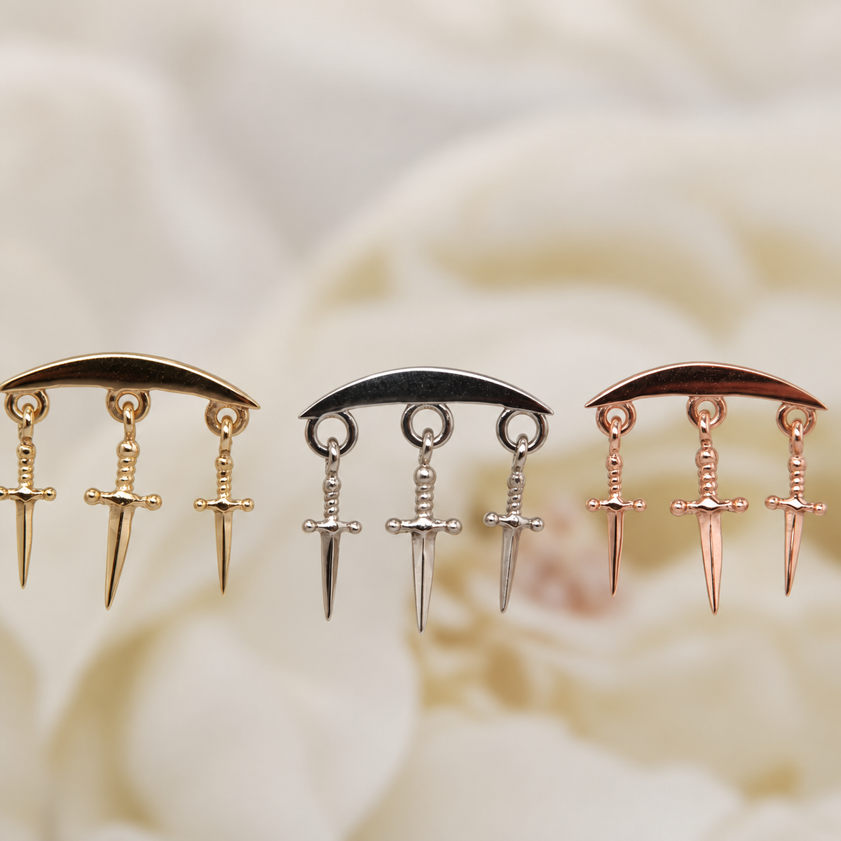 Norvoch 14k gold “Hidden Helix with Daggers” threaded end in yellow, white, and rose gold, featuring a sculptural curved design accented with three delicate dangling dagger charms