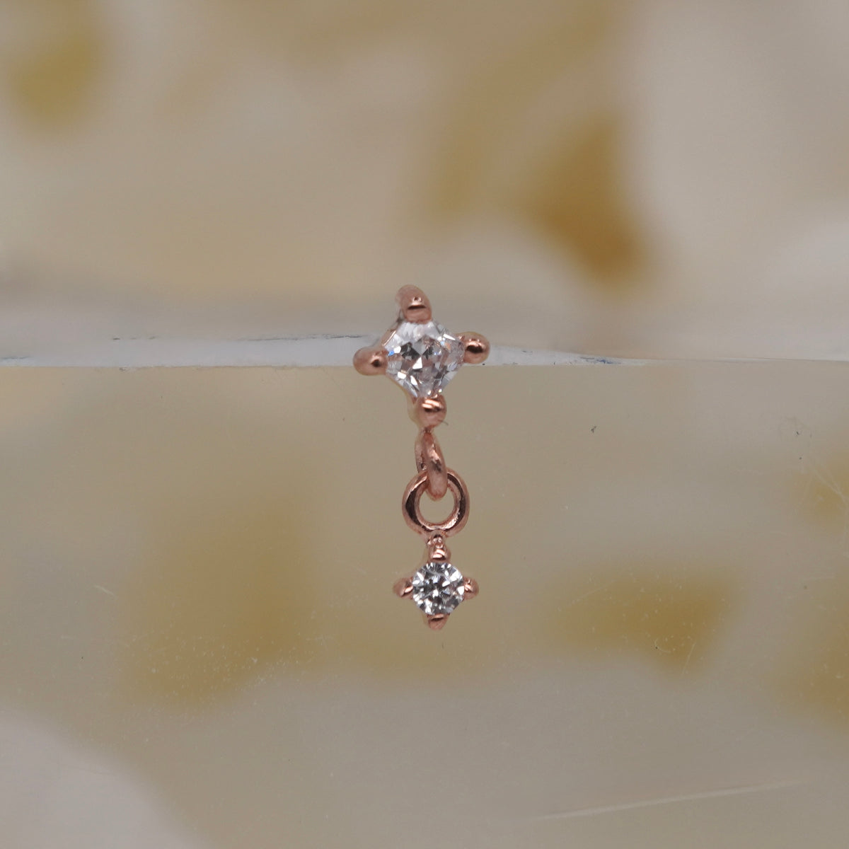 Buddha Jewelry 14k Gold fun and games small princess cut white crystal in a prong setting connected to a dangling small white crystal in a prong setting in Yellow Gold White Gold Rose Gold threadless