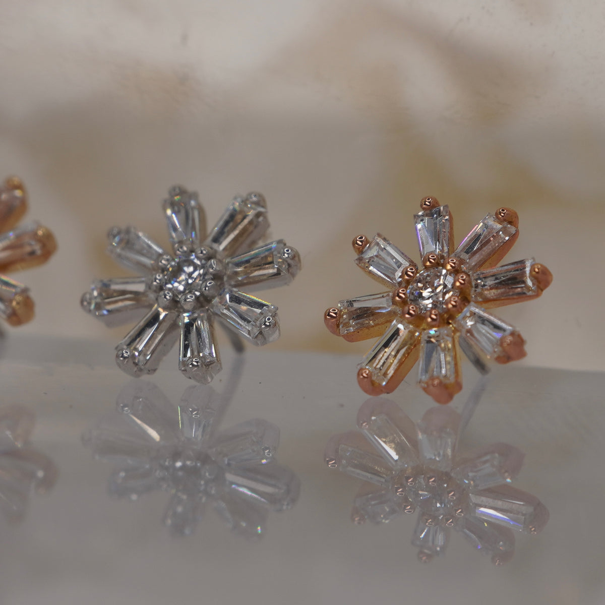 Angled view of Buddha Jewelry’s “Deliah” in 14k yellow, white, and rose gold, showing the dimensional starburst and tapered crystal petals.