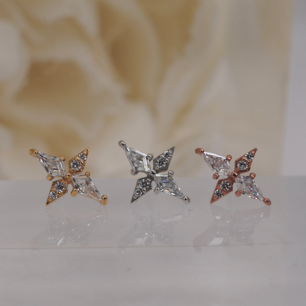 Front view of Buddha Jewelry’s “Feeling Myself” in 14k yellow, white, and rose gold, featuring an elongated, cross-like silhouette with crystal accents.