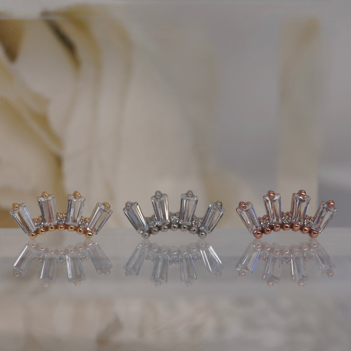 Front view of Buddha Jewelry’s “Crown Jewels” in 14k yellow, white, and rose gold, featuring an ornate crystal arrangement in a crown-like silhouette.