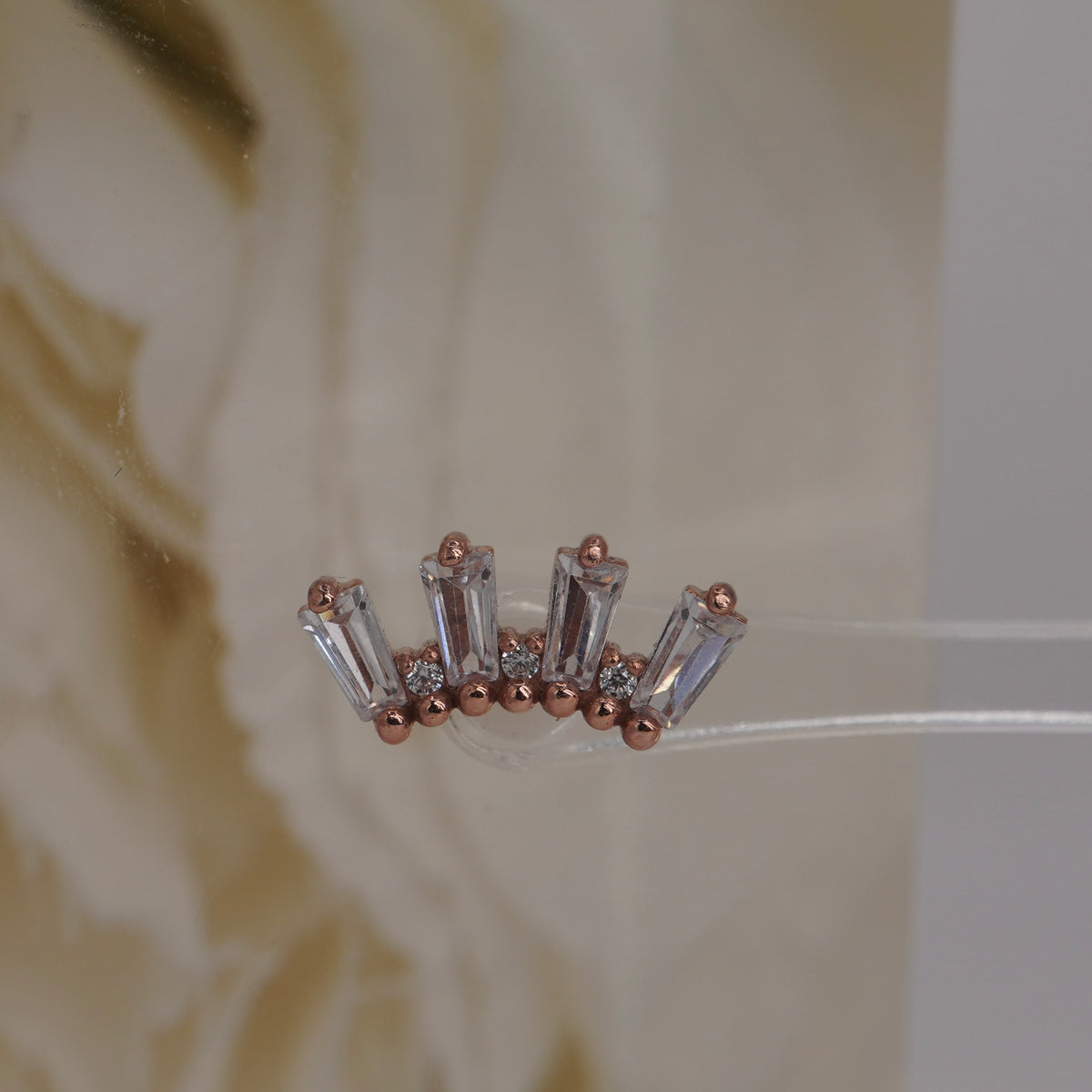 Front view of Buddha Jewelry’s “Crown Jewels” in 14k rose gold, featuring shimmering crystals arranged in an ornate crown-like shape.