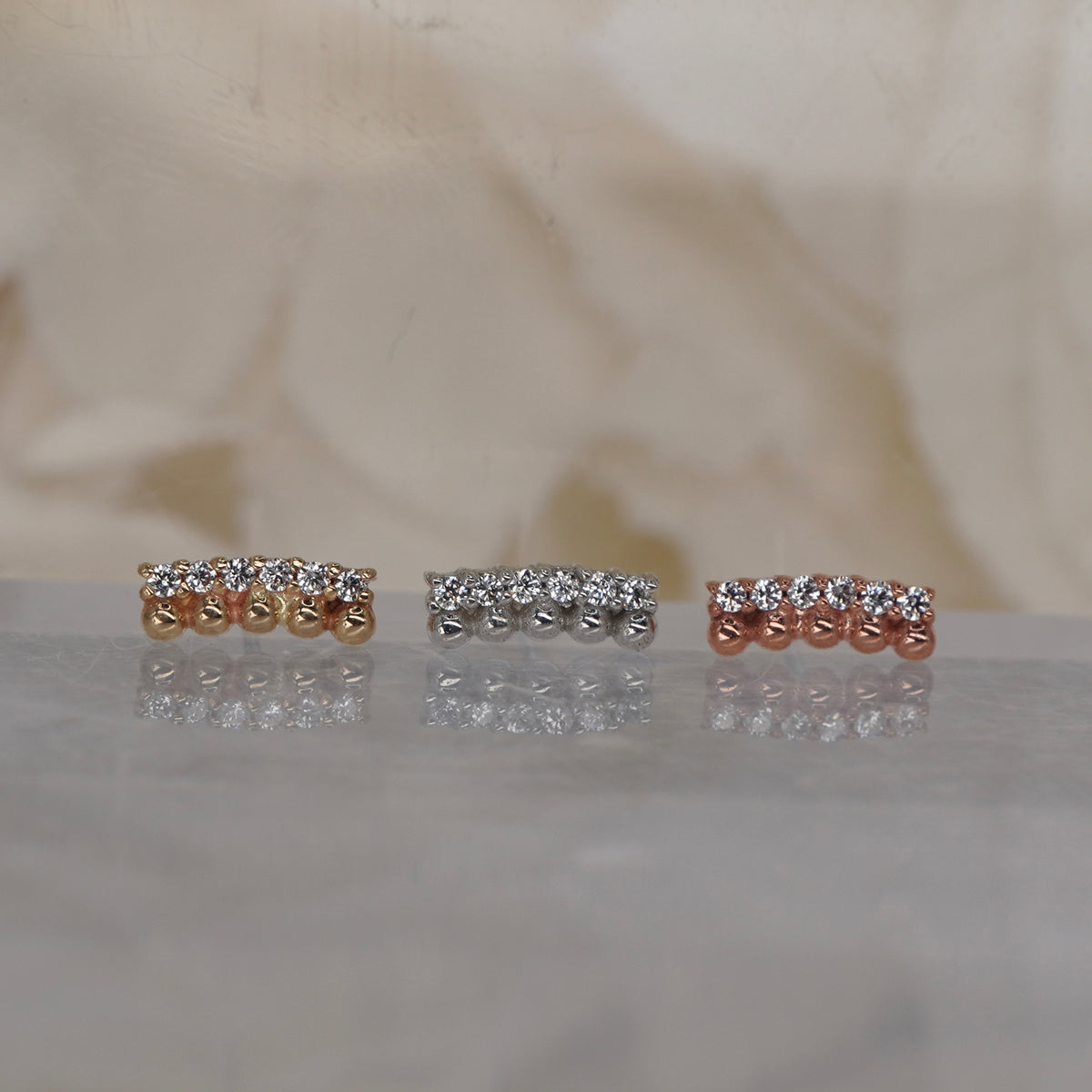 Front view of Buddha Jewelry’s “Prophesy” in 14k yellow, white, and rose gold, featuring parallel rows of polished gold beads and sparkling crystals.