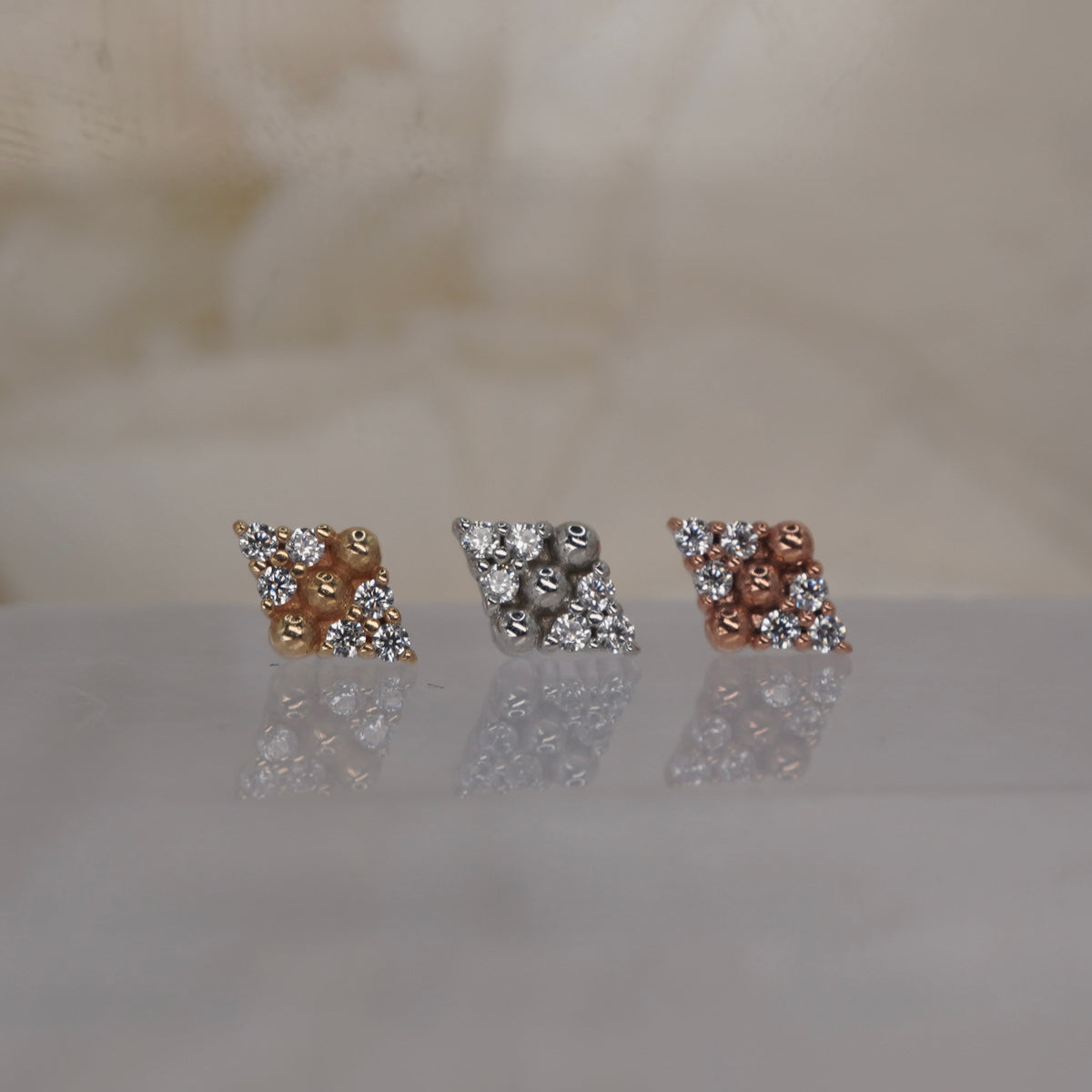 Front view of Buddha Jewelry’s “Lustre” in 14k yellow, white, and rose gold, featuring sparkling stones and polished gold beads in a balanced design.