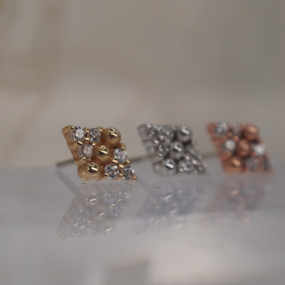 Angled view of Buddha Jewelry’s “Lustre” in 14k yellow, white, and rose gold, showing the dimensional arrangement of stones and polished beads.