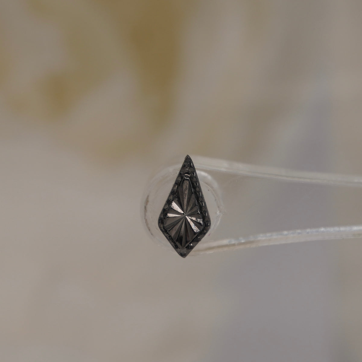 Upright view of Buddha Jewelry’s “Bad as Hell” in black rhodium, showing the reflective faceted texture and dimensional beaded detailing.