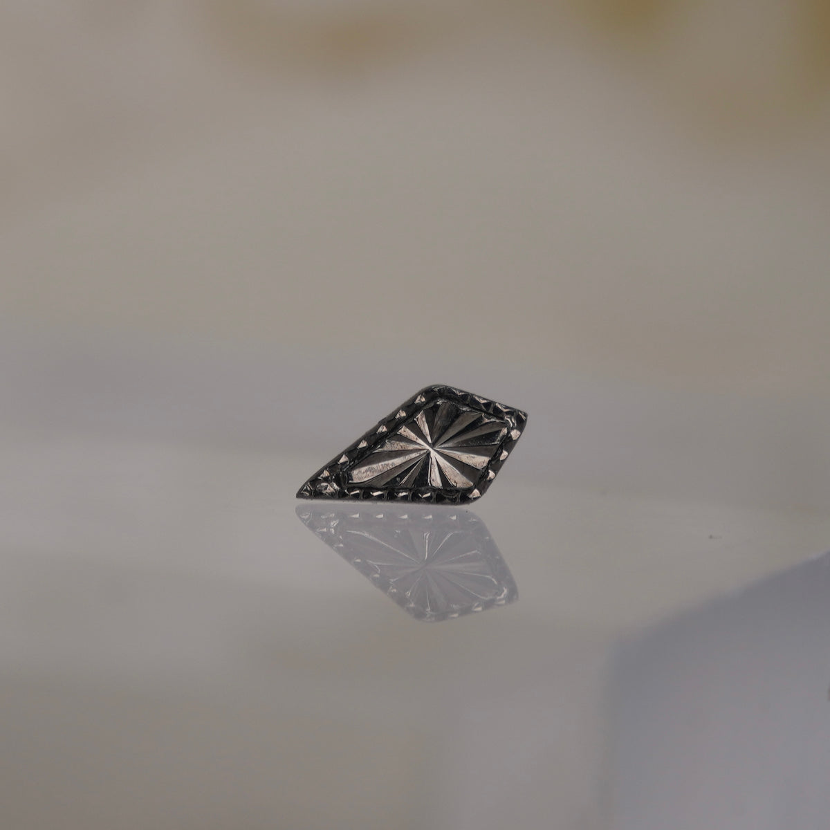 Front view of Buddha Jewelry’s “Bad as Hell” in black rhodium over solid gold, featuring a laser-cut, faceted center framed by beaded edges.