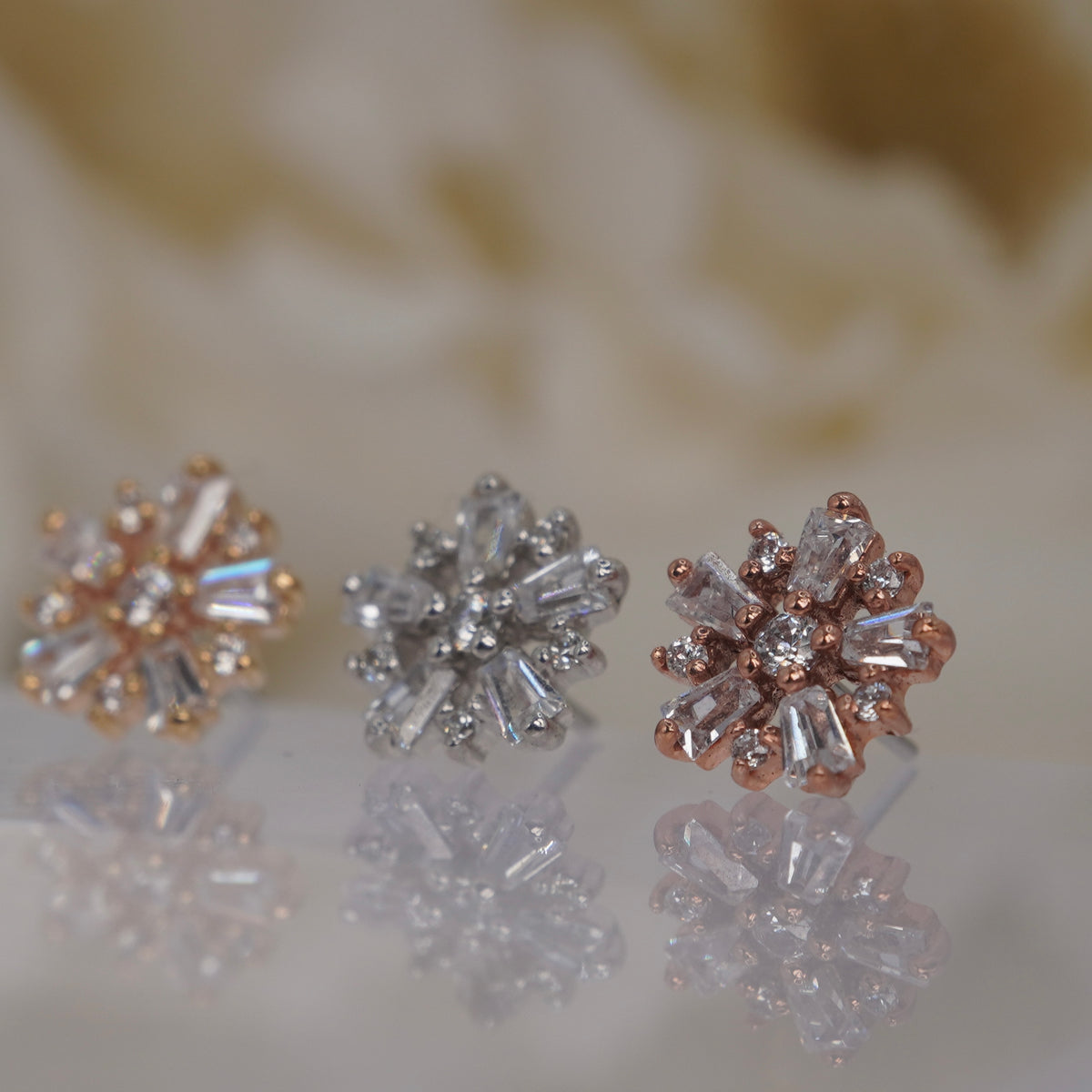 Angled view of Buddha Jewelry’s “Audacious” in 14k yellow, white, and rose gold, showing the dimensional floral arrangement of marquise and round crystals.