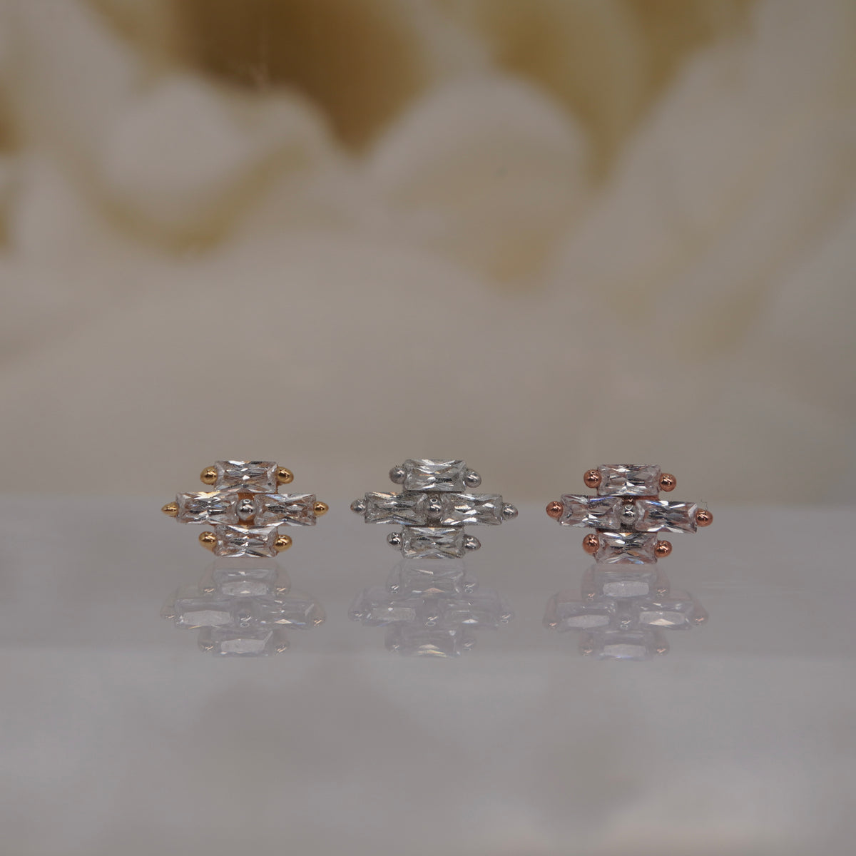 Front view of Buddha Jewelry’s “Fate” in 14k yellow, white, and rose gold, featuring elongated, baguette-style crystals in a symmetrical cluster.