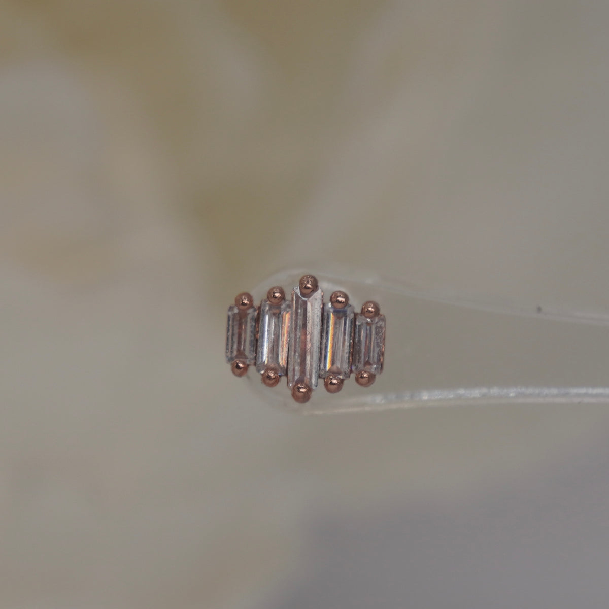 Front view of Buddha Jewelry’s “Evolution” in 14k rose gold, featuring elongated crystals arranged in a clean, graduated row.