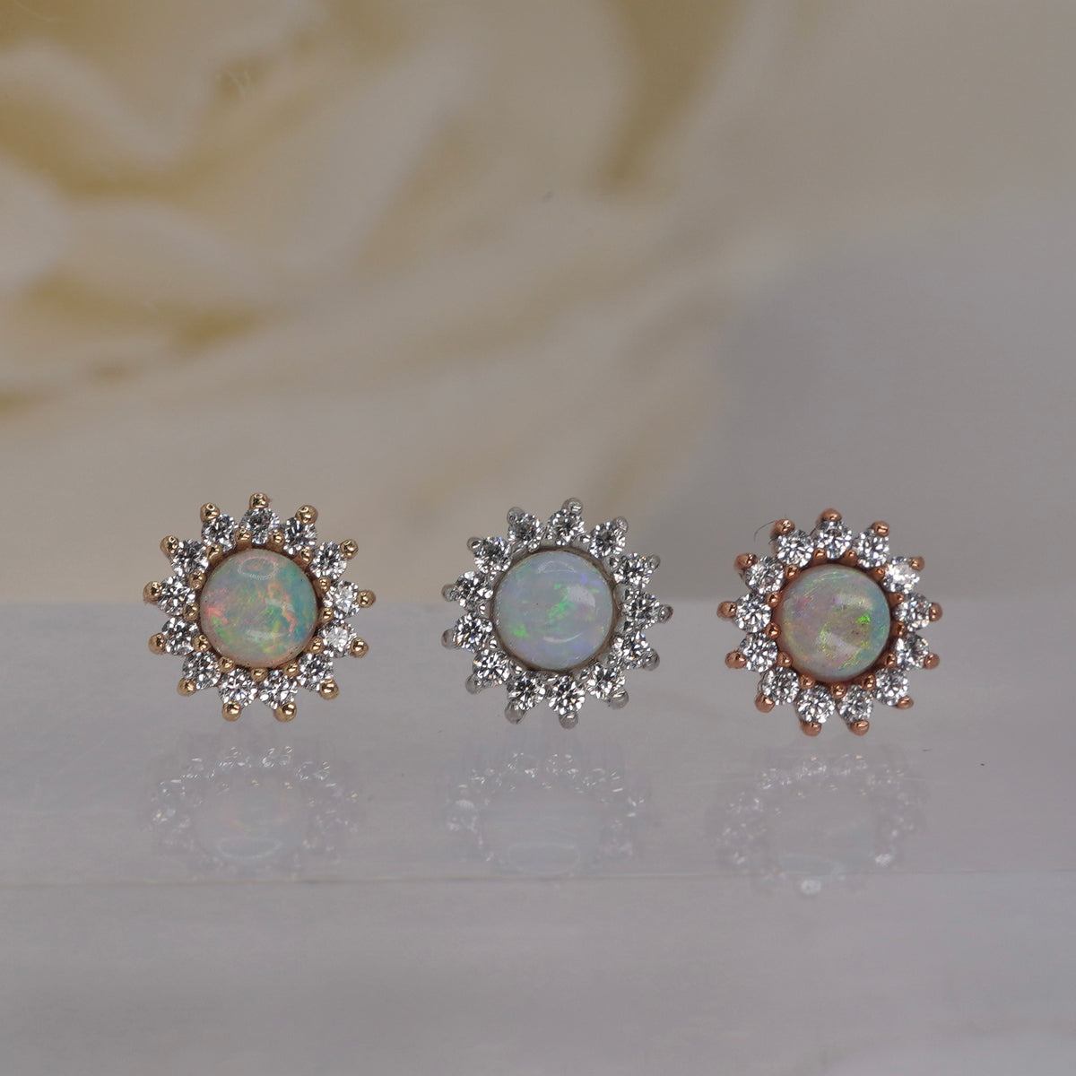 Front view of Buddha Jewelry’s “Delphine” in 14k yellow, white, and rose gold, featuring a luminous opal center surrounded by delicate crystal petals.